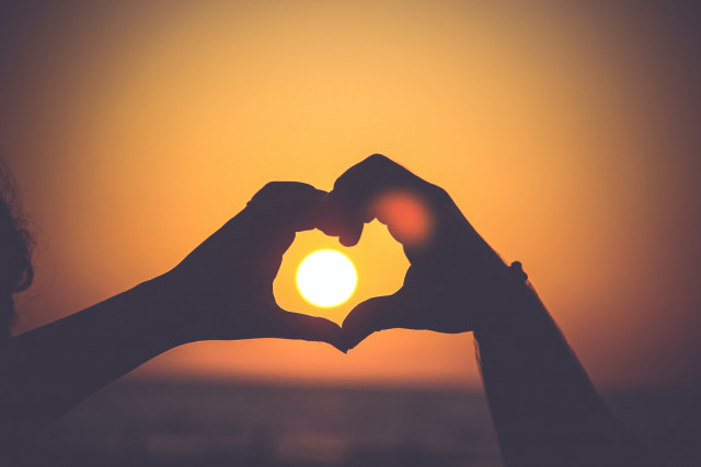 Romance sunset and heart hands